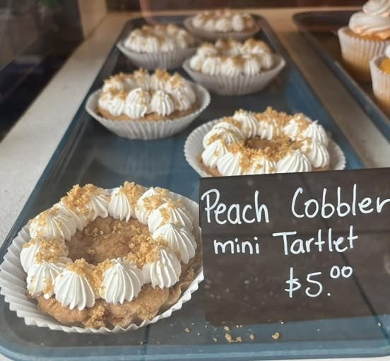 Peach cobbler mini tartlets topped with cream and a crumble