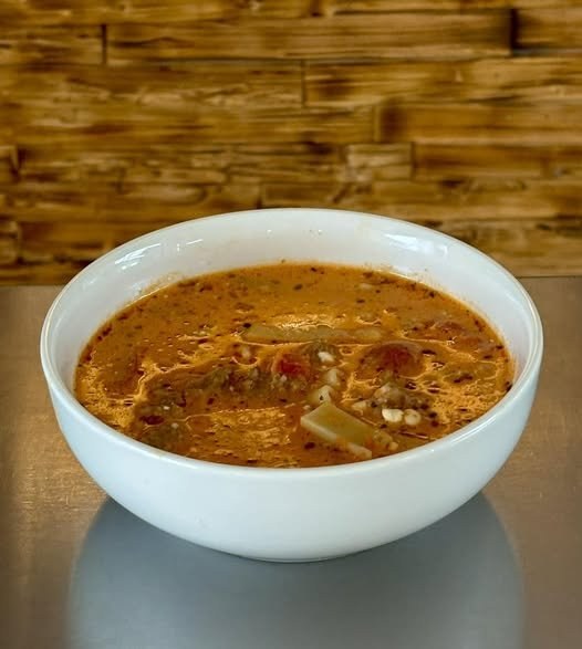 A bowl of hearty tomato and sausage soup